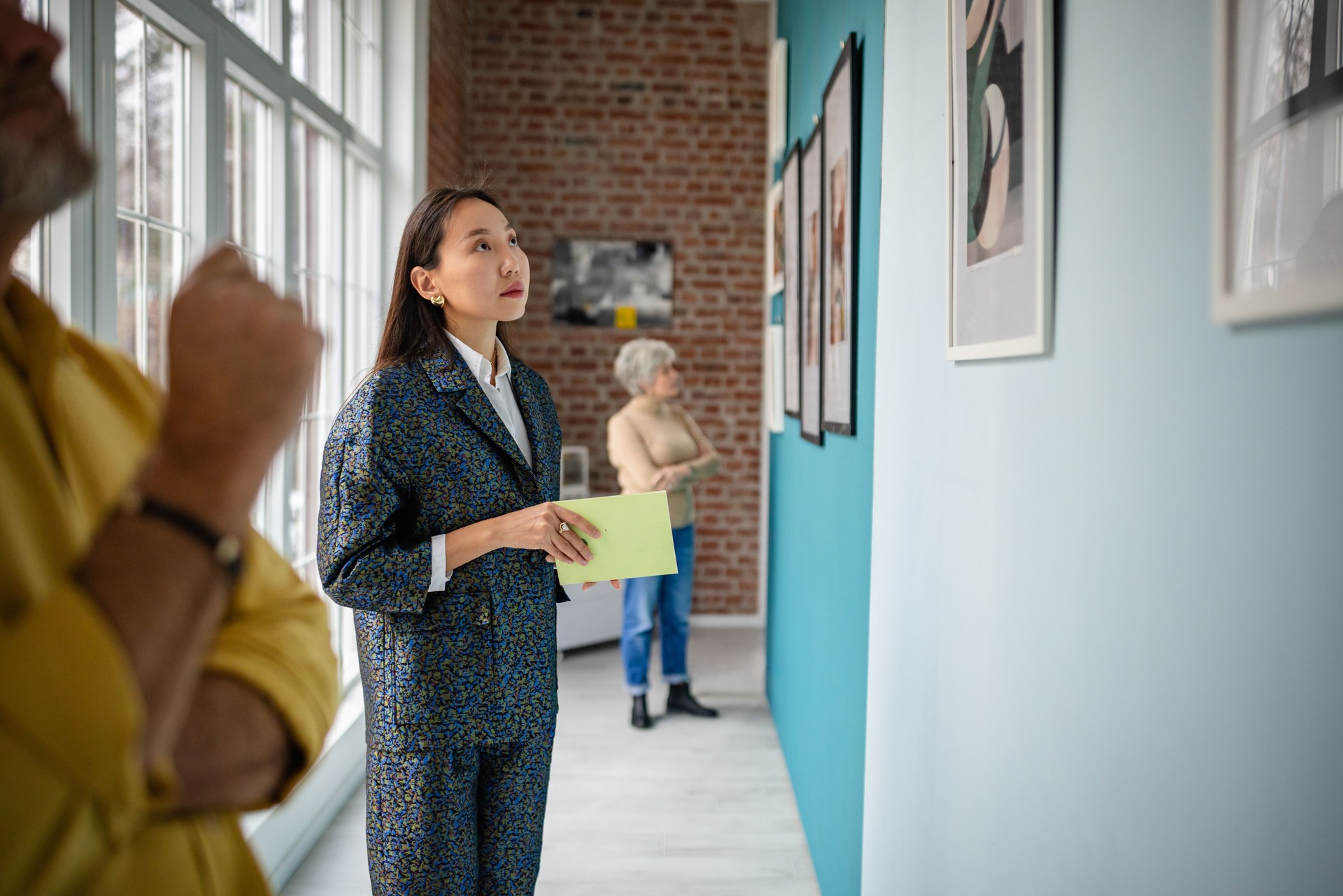 People exploring an art gallery exhibit with focus on the curator's role