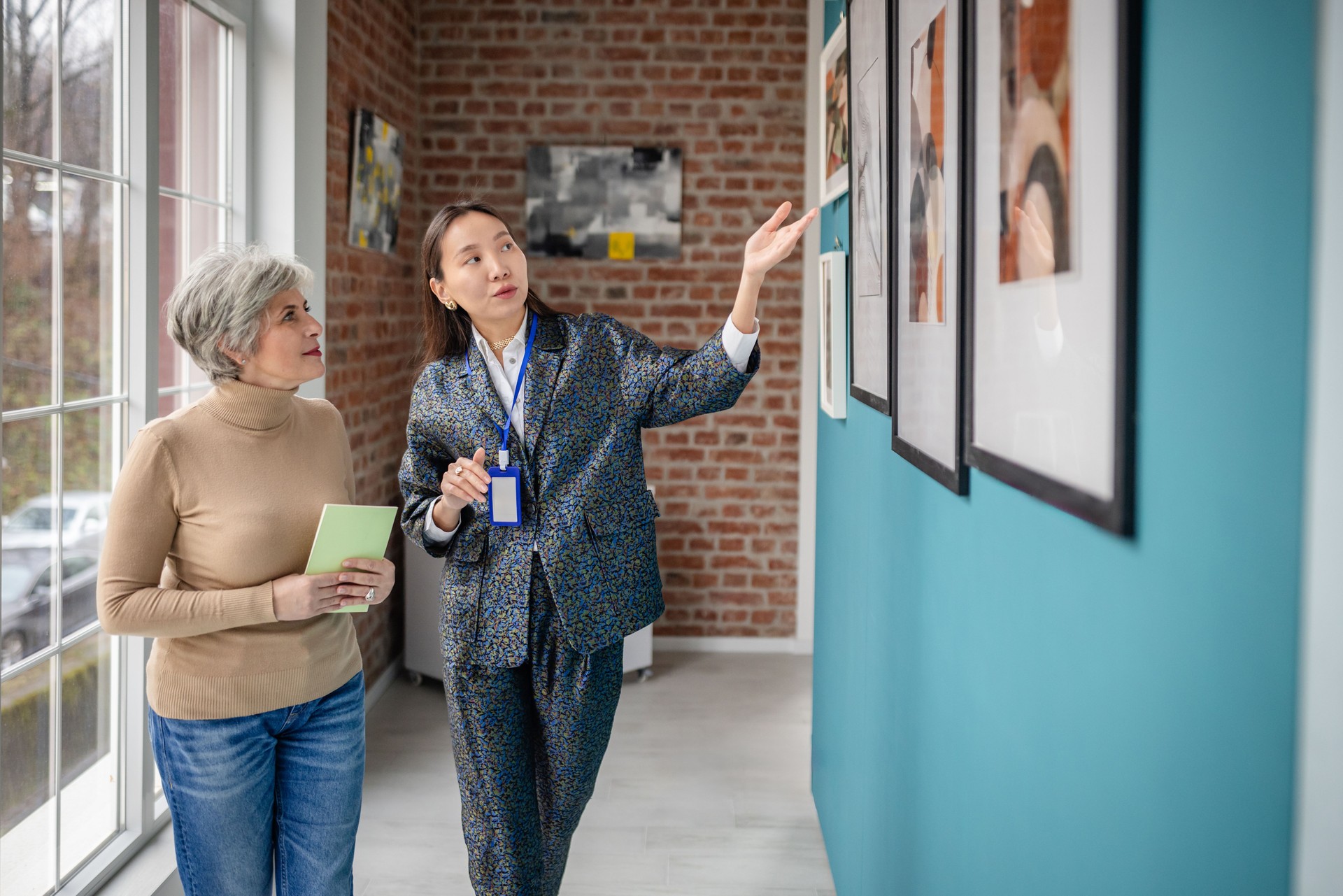 Curator Guiding Visitor in Contemporary Art Gallery Hallway Setting